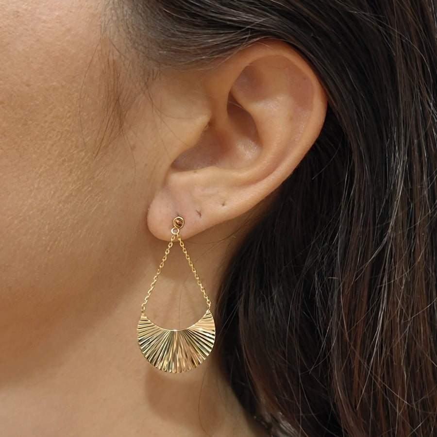 woman wearing gold plated earrings