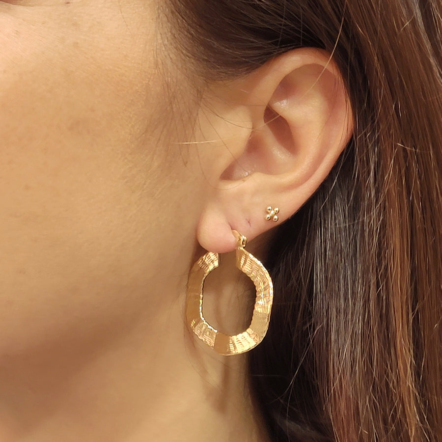 woman wearing gold plated earrings